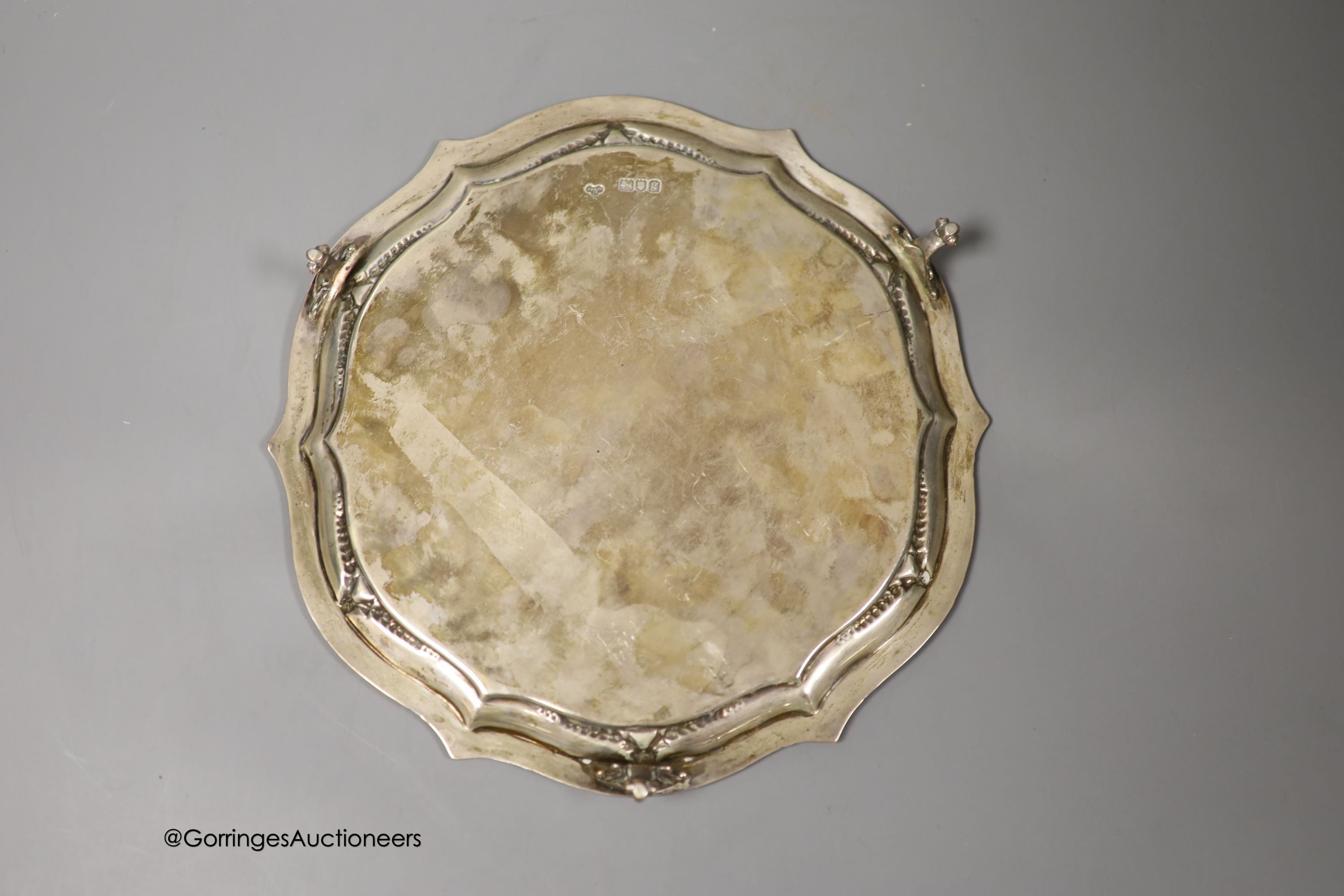 An Edwardian silver shaped circular salver, Goldsmiths & Silversmiths Co Ltd, London, 1902, 25cm and three silver napkin rings